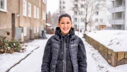 Leende ung kvinna i snöigt bostadsområde