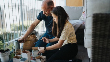 Pappa och dotter planterar växter på balkong